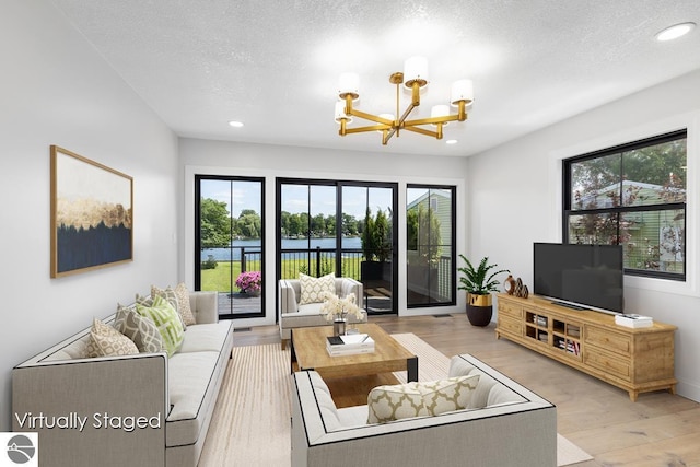 living area with an inviting chandelier, wood finished floors, and recessed lighting