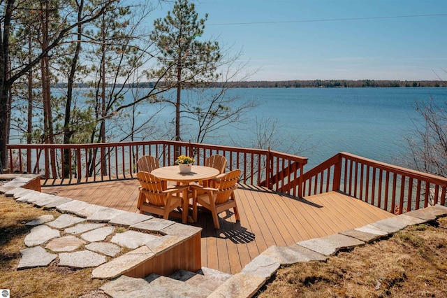 wooden terrace with outdoor dining space and a water view