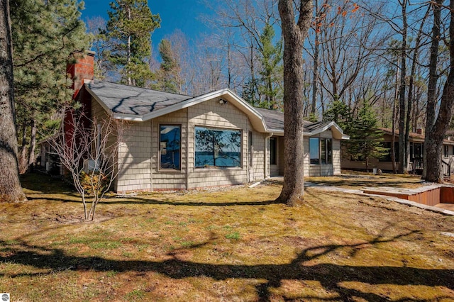 view of front of house featuring a chimney and a front yard