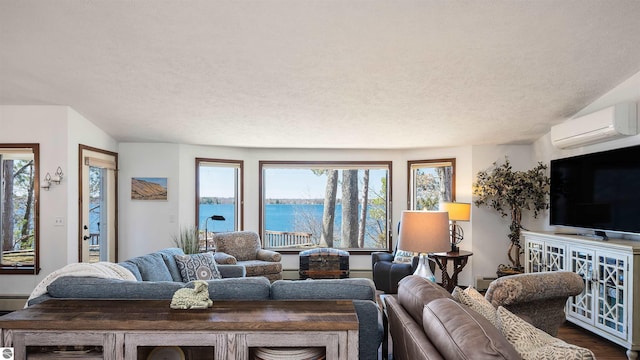 living area with an AC wall unit, dark wood-style flooring, a textured ceiling, and plenty of natural light
