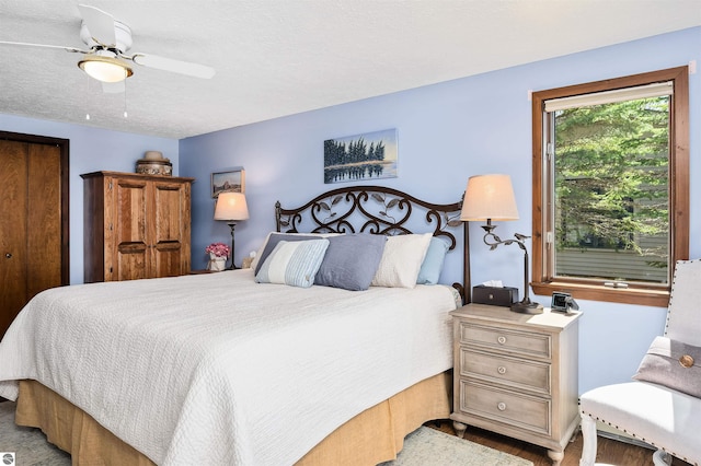 bedroom with a ceiling fan and a textured ceiling