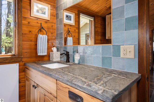 bathroom featuring wooden walls, tasteful backsplash, vanity, and wooden ceiling