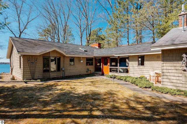 single story home featuring a chimney and roof with shingles
