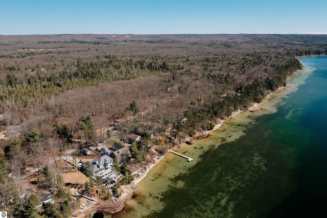 aerial view featuring a wooded view and a water view