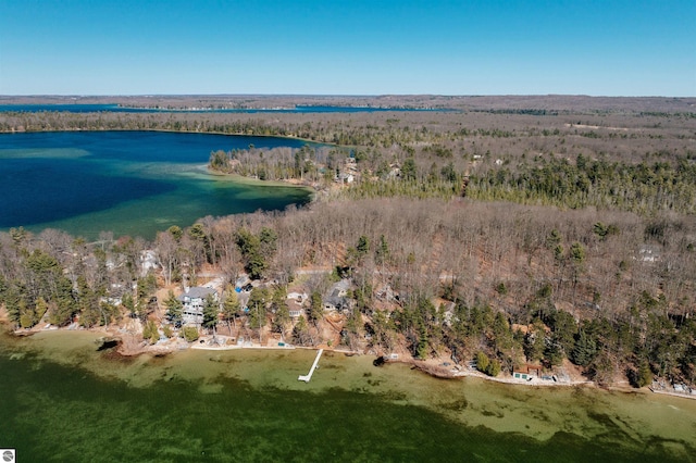 drone / aerial view with a forest view and a water view