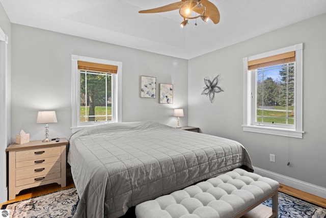 bedroom featuring baseboards, a ceiling fan, and wood finished floors