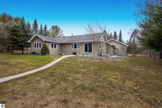 view of front of house with a front lawn and central air condition unit
