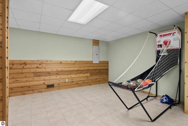 rec room with tile patterned floors, visible vents, and a drop ceiling