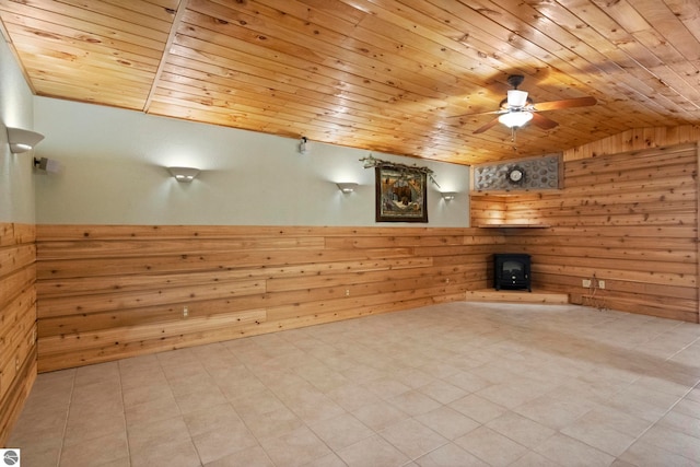 unfurnished living room with wooden walls, a ceiling fan, wooden ceiling, and lofted ceiling