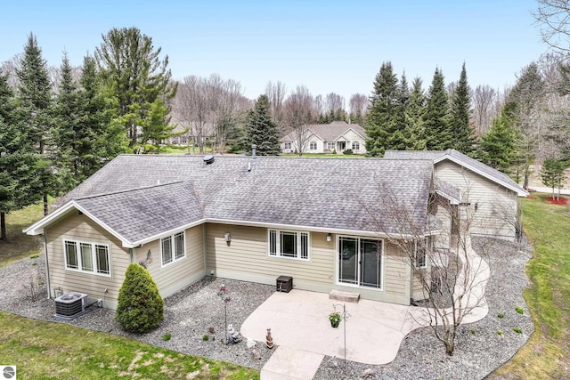 back of property with central air condition unit, a patio, and a shingled roof