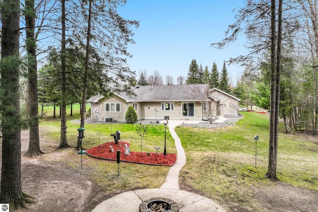 back of house featuring a lawn and an outdoor fire pit