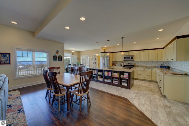 dining space with recessed lighting, light wood-style flooring, and baseboards