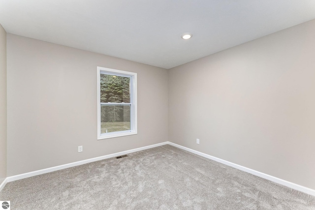 empty room featuring baseboards, visible vents, carpet, and recessed lighting