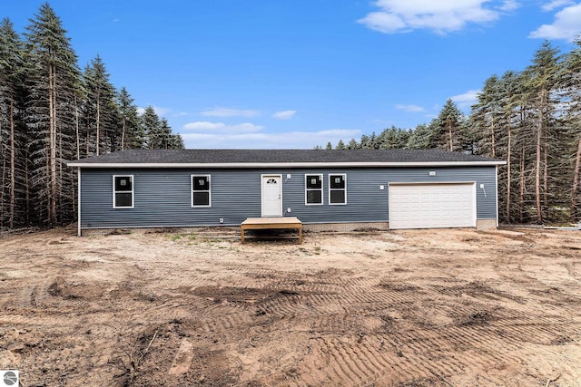 manufactured / mobile home with an attached garage and roof with shingles