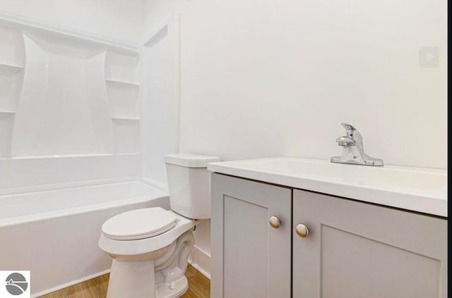 full bathroom with bathing tub / shower combination, wood finished floors, vanity, and toilet