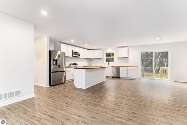 kitchen featuring white cabinets, recessed lighting, stainless steel appliances, visible vents, and light wood-style floors