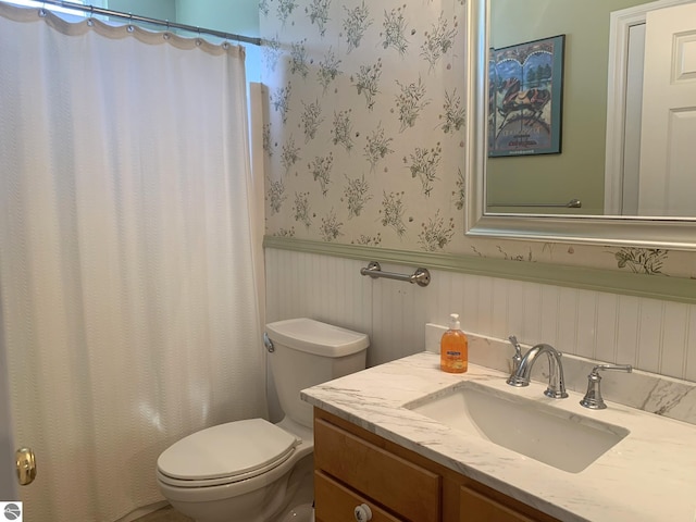 2708 Ruby St, Traverse City, MI 49684 - bathroom with wallpapered walls, a wainscoted wall, toilet, vanity, and curtained shower