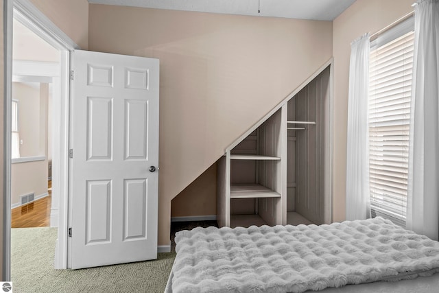 unfurnished bedroom featuring baseboards, visible vents, and carpet
