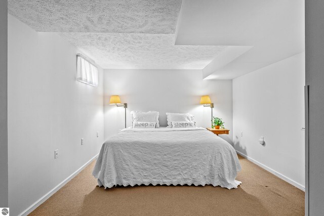 bedroom featuring baseboards, carpet flooring, and a textured ceiling