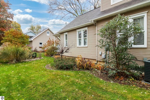 view of side of home with cooling unit and a lawn