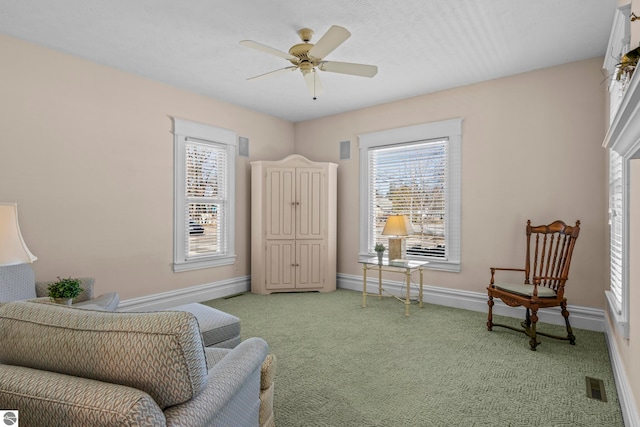 sitting room featuring plenty of natural light, light carpet, visible vents, and baseboards
