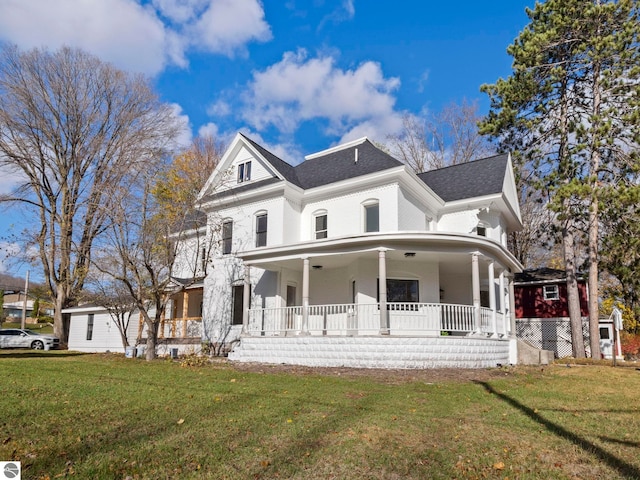 view of front facade with roof with shingles, a front lawn, and covered porch