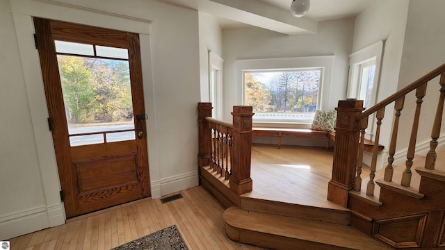 foyer entrance with plenty of natural light, visible vents, and light wood finished floors