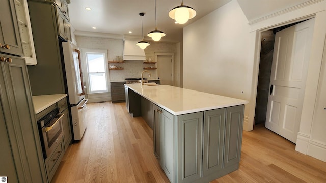 kitchen featuring light countertops, freestanding refrigerator, open shelves, and oven