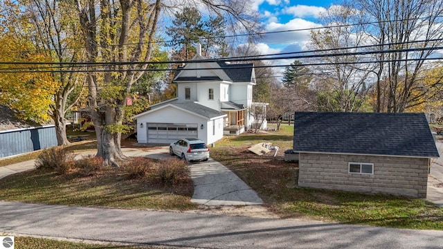 traditional home with driveway, roof with shingles, and a garage