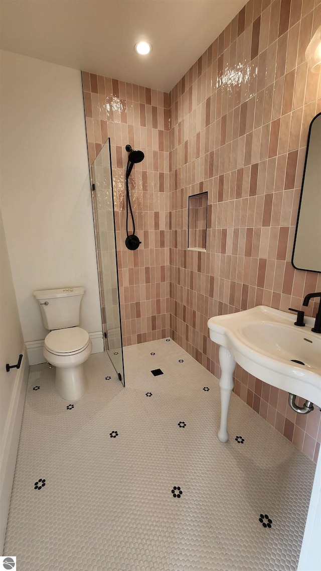 full bathroom with a sink, a tile shower, toilet, tile patterned flooring, and recessed lighting