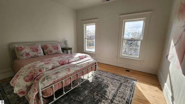 bedroom with visible vents and light wood-style flooring