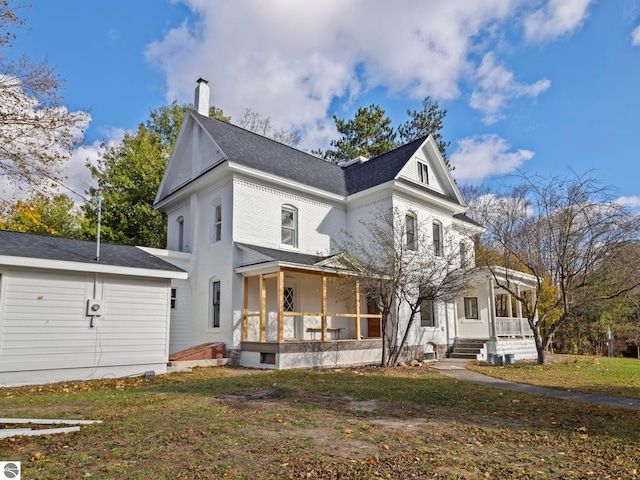 exterior space with a chimney, a porch, and a lawn