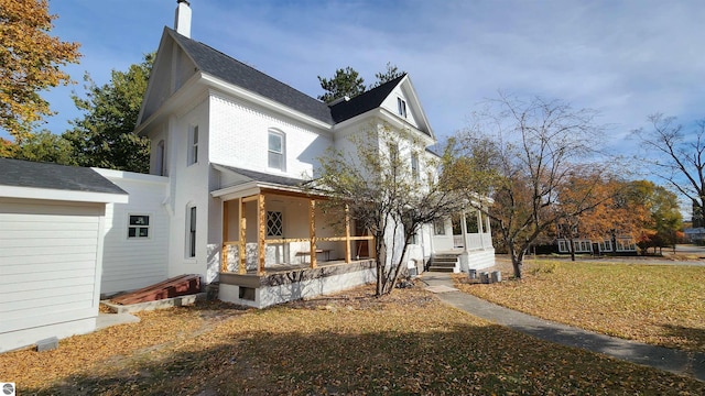 exterior space with a porch and a chimney
