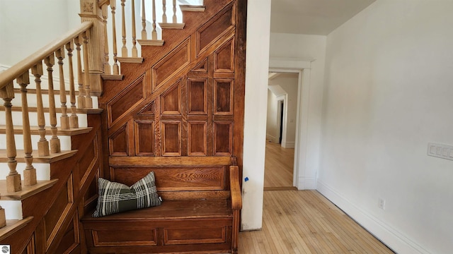 stairway featuring wood finished floors and baseboards