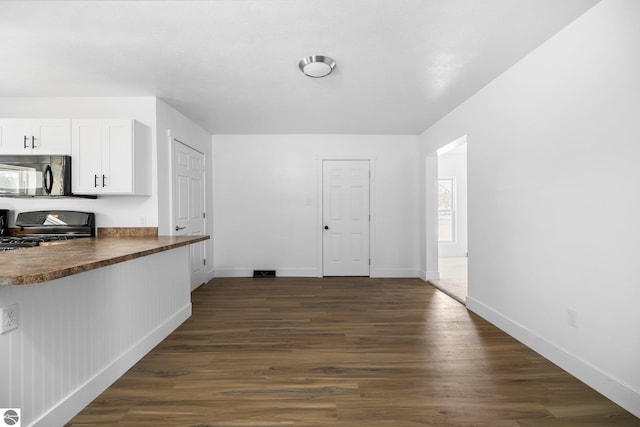 419 S Cherry St, Kalkaska, MI 49646 - interior space featuring baseboards and dark wood finished floors