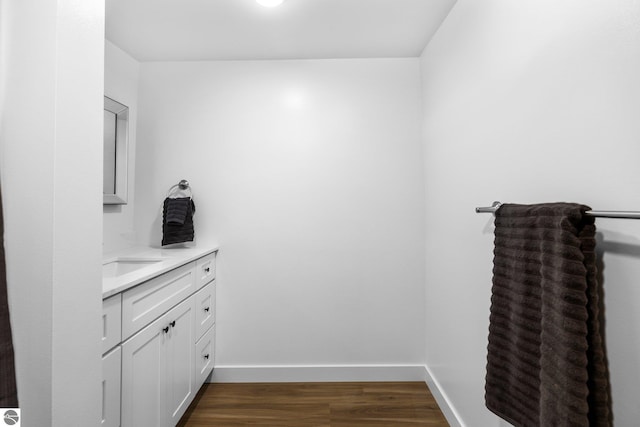 419 S Cherry St, Kalkaska, MI 49646 - bathroom featuring baseboards, wood finished floors, and vanity