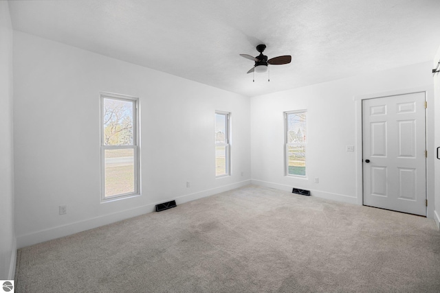 419 S Cherry St, Kalkaska, MI 49646 - carpeted spare room with visible vents, a ceiling fan, and baseboards