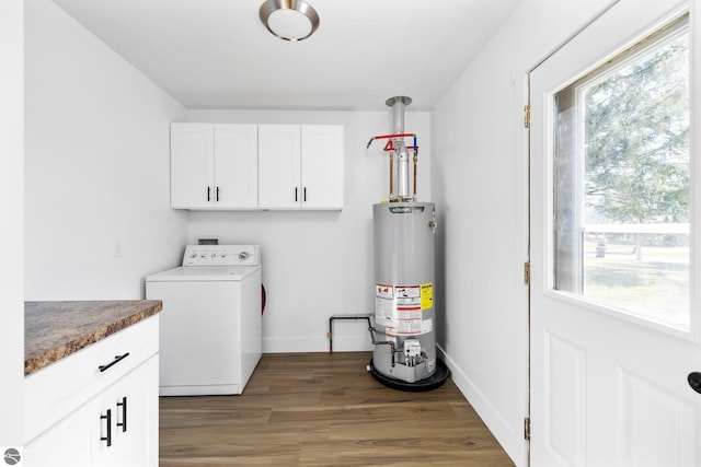 419 S Cherry St, Kalkaska, MI 49646 - laundry area featuring gas water heater, dark wood-style flooring, baseboards, washer / clothes dryer, and cabinet space