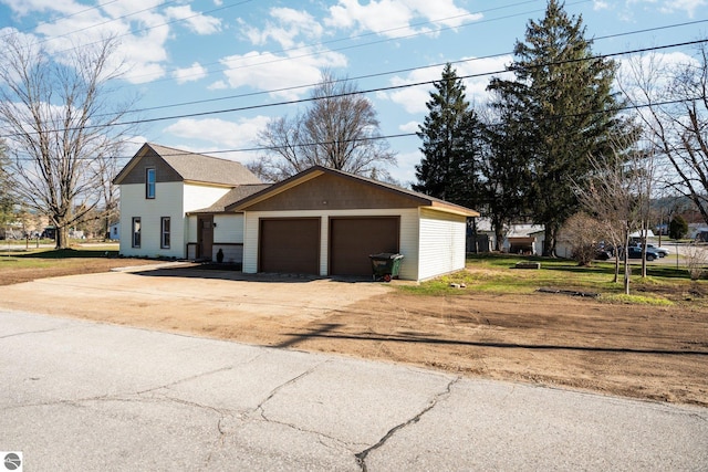 419 S Cherry St, Kalkaska, MI 49646 - view of front of property with driveway, an outdoor structure, and a garage