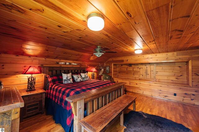 bedroom featuring a sauna, light wood-style floors, lofted ceiling, wood walls, and wood ceiling