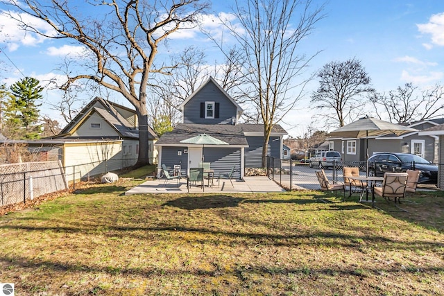 rear view of property featuring a lawn, a patio, and fence