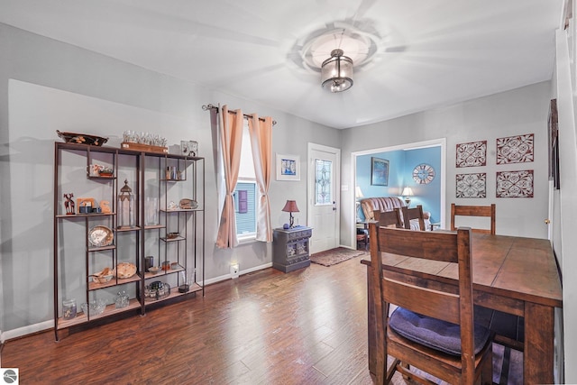 dining space with baseboards and wood finished floors