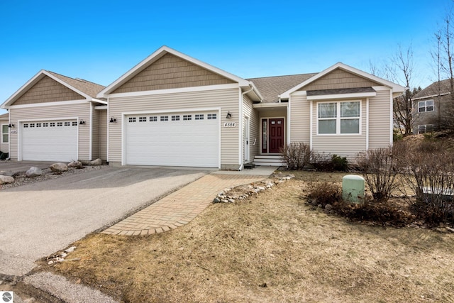 4584 Kodiak Dr, Traverse City, MI 49685 - single story home with an attached garage, driveway, and a shingled roof