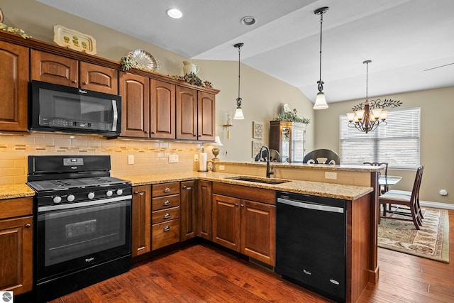 4584 Kodiak Dr, Traverse City, MI 49685 - kitchen with vaulted ceiling, a sink, dark wood-type flooring, black appliances, and a peninsula