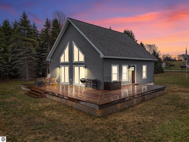 5891 Voice Rd, Kingsley, MI 49649 - back of property at dusk featuring a wooden deck, a shingled roof, and a yard