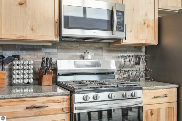 5891 Voice Rd, Kingsley, MI 49649 - kitchen with decorative backsplash, light brown cabinetry, light stone counters, and appliances with stainless steel finishes
