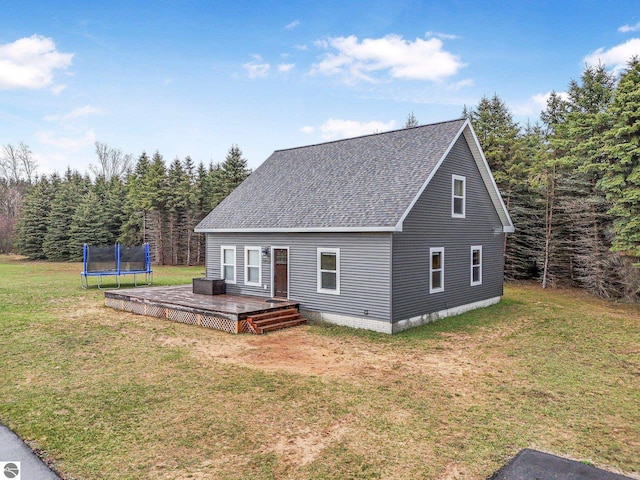 5891 Voice Rd, Kingsley, MI 49649 - view of front of home featuring a wooden deck, a trampoline, roof with shingles, and a front lawn
