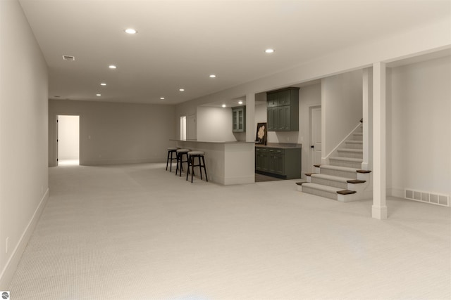 203 Vineyard Ridge Dr Unit 38, Traverse City, MI 49686 - below grade area with baseboards, visible vents, recessed lighting, light colored carpet, and stairs