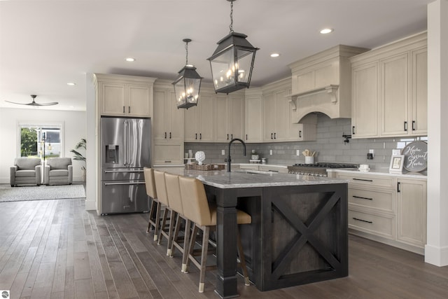 203 Vineyard Ridge Dr Unit 38, Traverse City, MI 49686 - kitchen with high end refrigerator, tasteful backsplash, ceiling fan with notable chandelier, a kitchen bar, and dark wood-type flooring