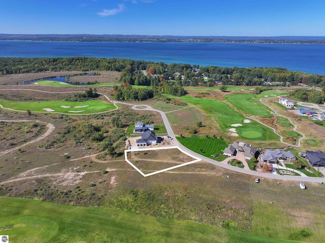 aerial view of property and surrounding area featuring a large body of water, property parcel outlined, and a golf course